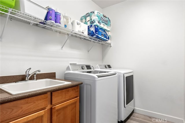 341 W Pebble Creek Ln, Orange, CA 92865 - laundry area with washing machine and clothes dryer, light wood-style flooring, baseboards, and cabinet space