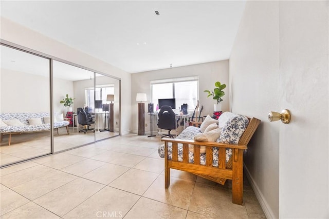 9038 Orion Ave Unit 107, North Hills, CA 91343 - living area featuring light tile patterned floors, an office area, and baseboards