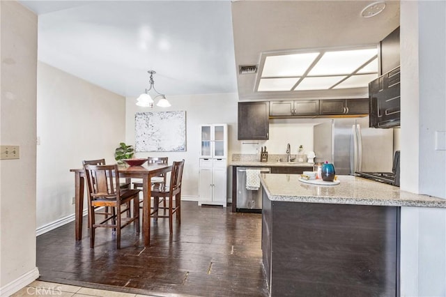 9038 Orion Ave Unit 107, North Hills, CA 91343 - kitchen with stainless steel appliances, dark wood-style flooring, dark brown cabinetry, and a peninsula