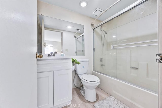 9038 Orion Ave Unit 107, North Hills, CA 91343 - bathroom with toilet, bath / shower combo with glass door, wood finished floors, and vanity
