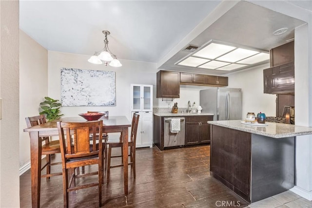 9038 Orion Ave Unit 107, North Hills, CA 91343 - kitchen with stainless steel appliances, a sink, dark brown cabinets, a chandelier, and dark wood-style flooring