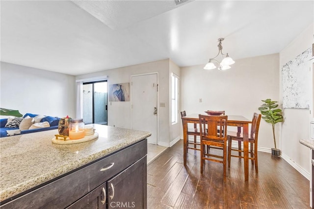 9038 Orion Ave Unit 107, North Hills, CA 91343 - kitchen with dark wood finished floors, dark brown cabinets, light stone counters, hanging light fixtures, and a chandelier