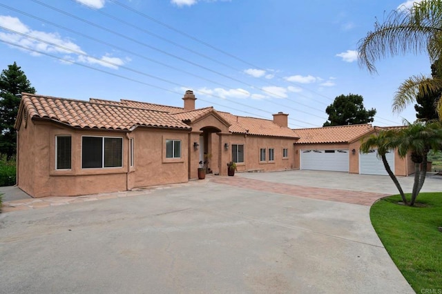 4036 Stonebridge Ln, Rancho Santa Fe, CA 92091 - mediterranean / spanish-style house featuring stucco siding, a tiled roof, a chimney, an outbuilding, and a detached garage