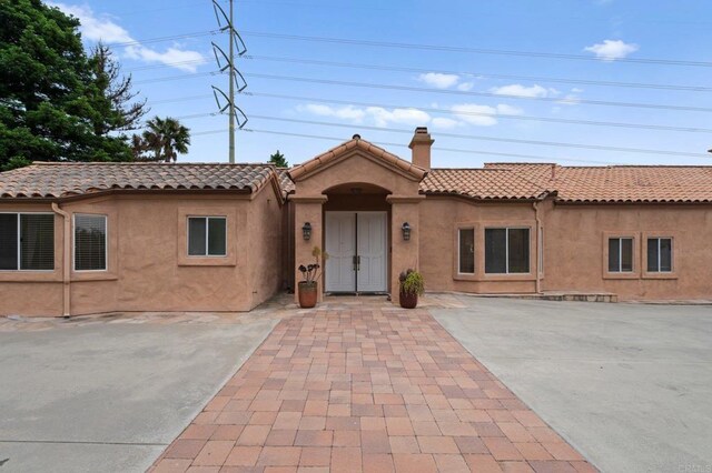 4036 Stonebridge Ln, Rancho Santa Fe, CA 92091 - view of front of home featuring a chimney, a tile roof, and stucco siding