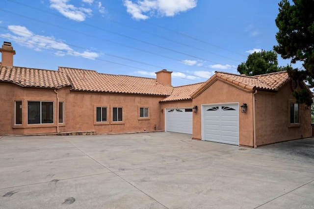 4036 Stonebridge Ln, Rancho Santa Fe, CA 92091 - view of side of property featuring a chimney, an attached garage, driveway, and a tiled roof