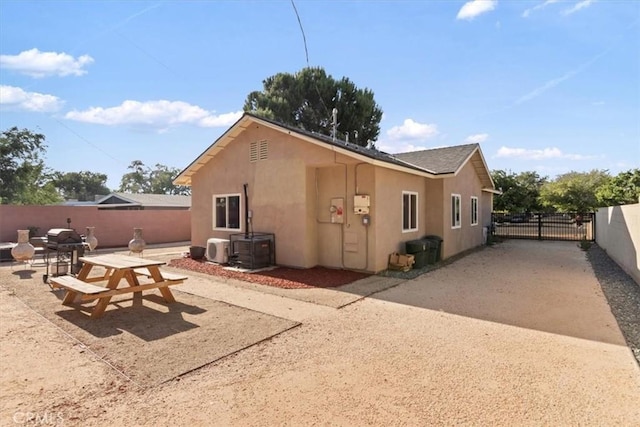350 E Nugent St, Lancaster, CA 93535 - view of side of home with stucco siding, a patio, a gate, and a cooling unit