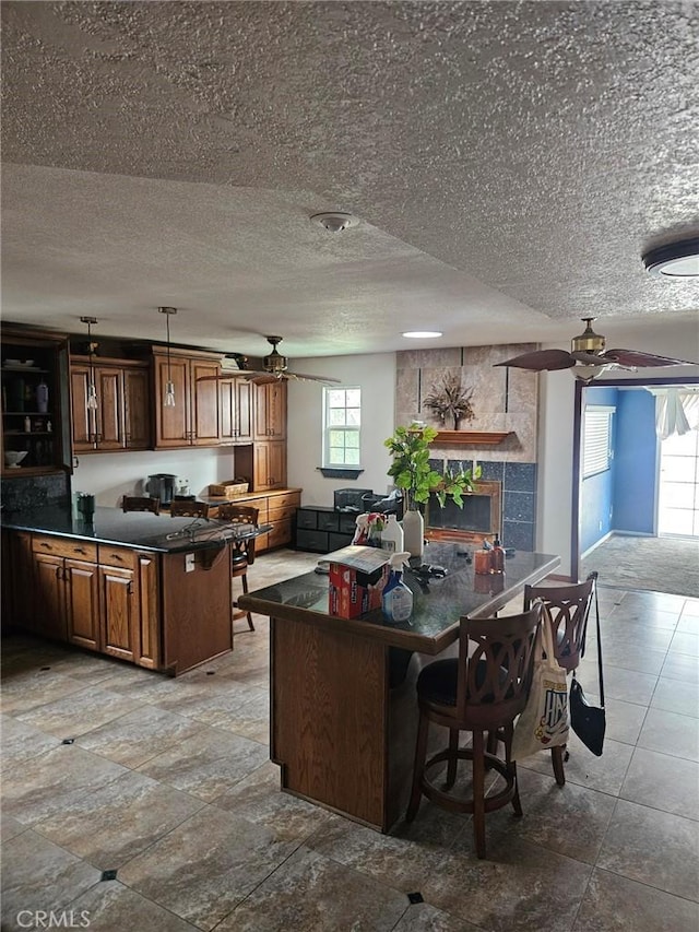 1364 El Lugar, Chula Vista, CA 91911 - kitchen with a ceiling fan, dark countertops, a textured ceiling, open floor plan, and brown cabinetry
