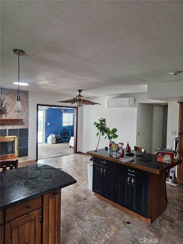 1364 El Lugar, Chula Vista, CA 91911 - kitchen featuring dark countertops, a kitchen island, a textured ceiling, a tile fireplace, and a ceiling fan
