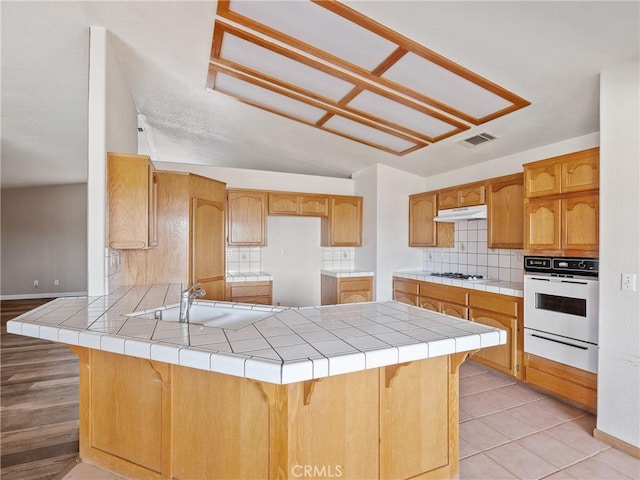 13951 Falling Leaf Rd, Apple Valley, CA 92307 - kitchen with white appliances, a warming drawer, a peninsula, a sink, and baseboards