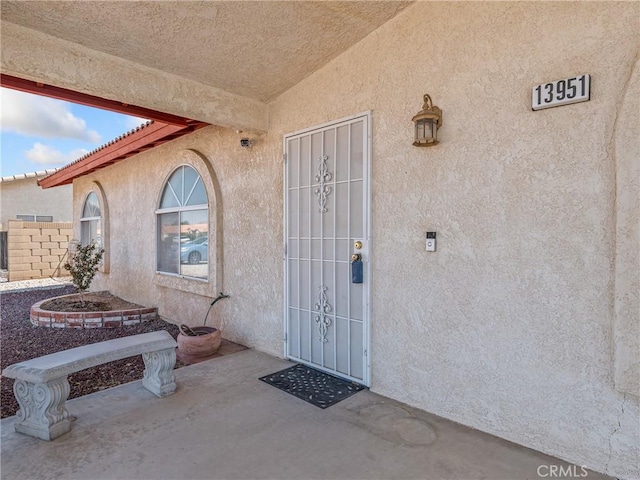 13951 Falling Leaf Rd, Apple Valley, CA 92307 - property entrance with stucco siding and a patio area