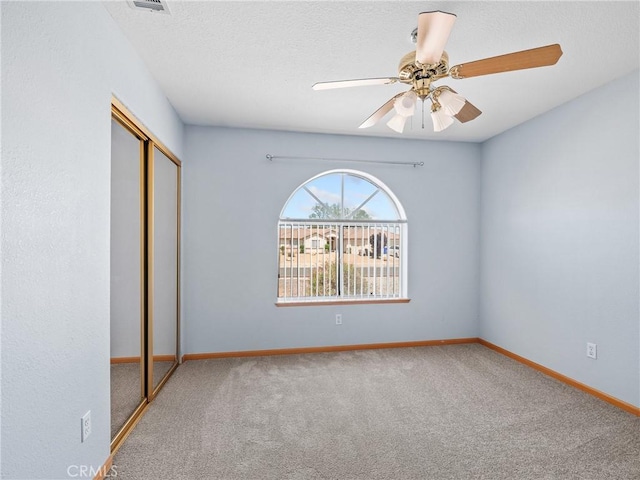 13951 Falling Leaf Rd, Apple Valley, CA 92307 - unfurnished bedroom with a closet, carpet floors, baseboards, ceiling fan, and a textured ceiling