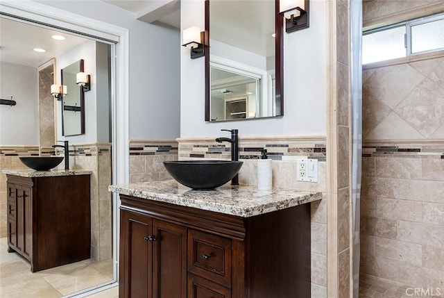 2212 Rim Rd, Duarte, CA 91008 - bathroom with tile walls, two vanities, a wainscoted wall, tile patterned flooring, and a tile shower