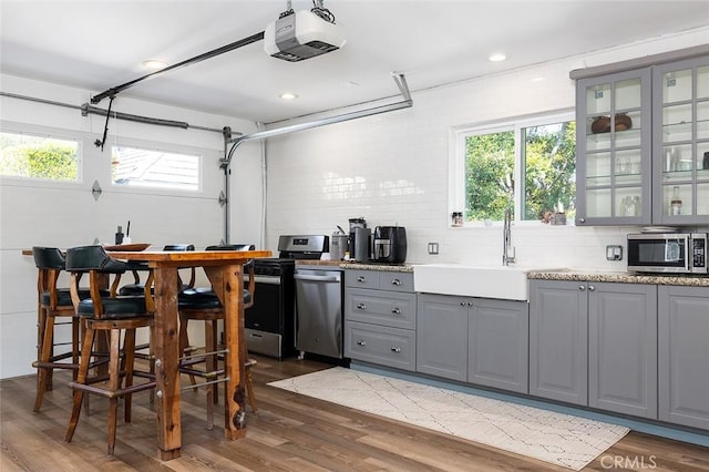 2212 Rim Rd, Duarte, CA 91008 - kitchen with gray cabinets, stainless steel appliances, dark wood-type flooring, tasteful backsplash, and glass insert cabinets