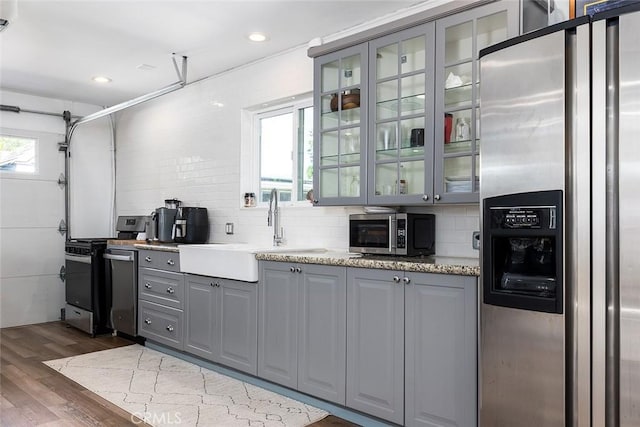 2212 Rim Rd, Duarte, CA 91008 - kitchen featuring stainless steel appliances, gray cabinetry, tasteful backsplash, dark wood-type flooring, and glass insert cabinets