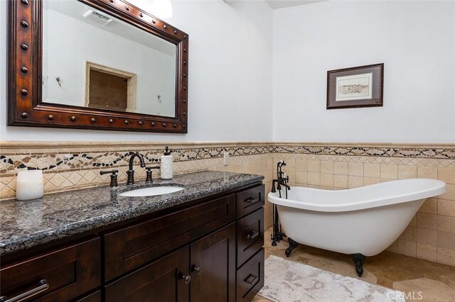2212 Rim Rd, Duarte, CA 91008 - bathroom with tile walls, vanity, a freestanding tub, a wainscoted wall, and tile patterned floors