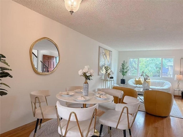333 S Arroyo Dr Unit J, San Gabriel, CA 91776 - dining space with a textured ceiling, wood finished floors, and baseboards