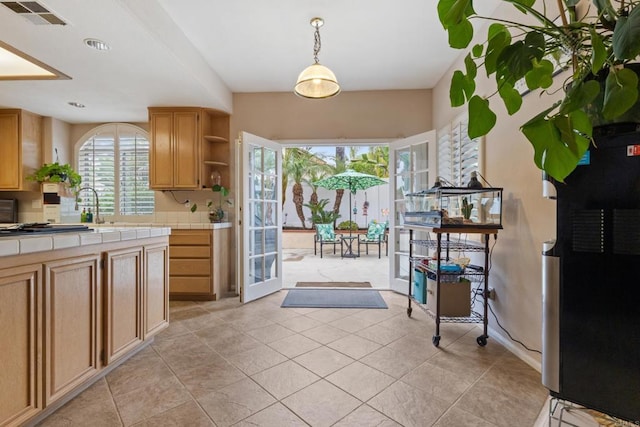 1394 Corte Magna, Oceanside, CA 92057 - kitchen featuring tile counters, open shelves, freestanding refrigerator, light tile patterned floors, and decorative light fixtures