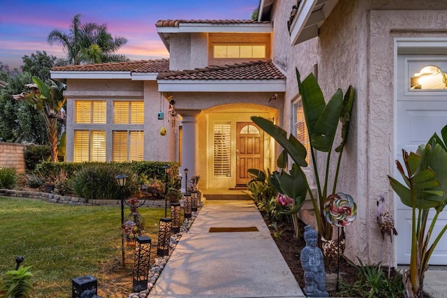 1394 Corte Magna, Oceanside, CA 92057 - exterior entry at dusk featuring stucco siding, a lawn, and a tile roof