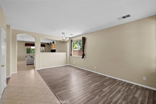 4616 W W Ave J2, Lancaster, CA 93536 - spare room featuring arched walkways, a chandelier, baseboards, and light wood-style floors