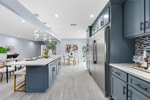 7321 Eglise Ave, Pico Rivera, CA 90660 - kitchen featuring high quality fridge, a kitchen island, tasteful backsplash, light wood-style floors, and recessed lighting