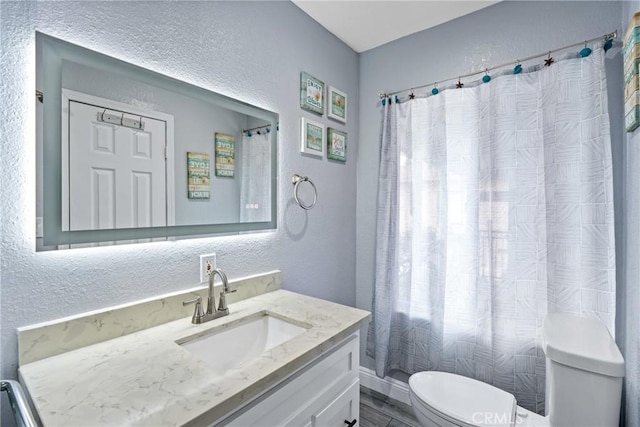 7321 Eglise Ave, Pico Rivera, CA 90660 - full bath featuring a textured wall, toilet, vanity, and wood finished floors