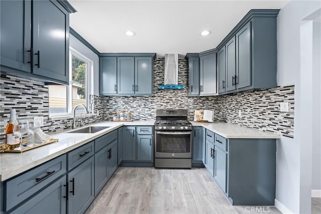 7321 Eglise Ave, Pico Rivera, CA 90660 - kitchen featuring gas stove, wall chimney exhaust hood, light wood finished floors, backsplash, and recessed lighting