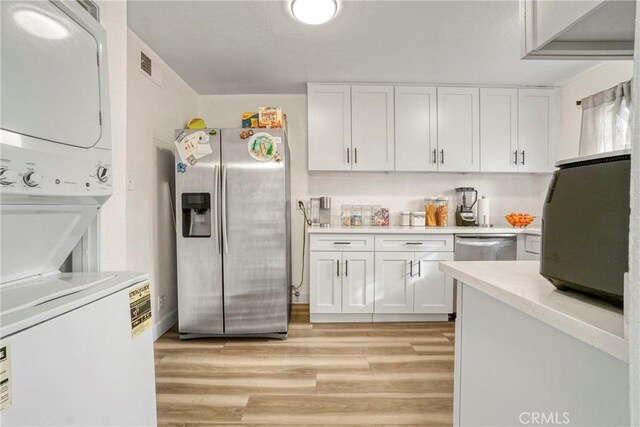 9414 Moonbeam Ave Unit 18, Panorama City, CA 91402 - kitchen with stainless steel appliances, stacked washer / dryer, white cabinets, and light countertops