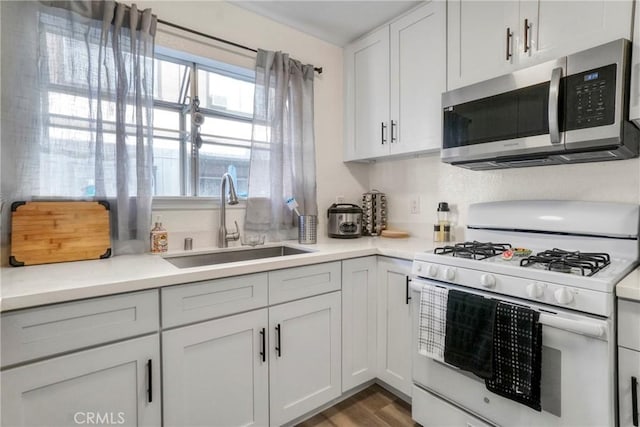9414 Moonbeam Ave Unit 18, Panorama City, CA 91402 - kitchen featuring white gas stove, stainless steel microwave, a sink, light countertops, and wood finished floors