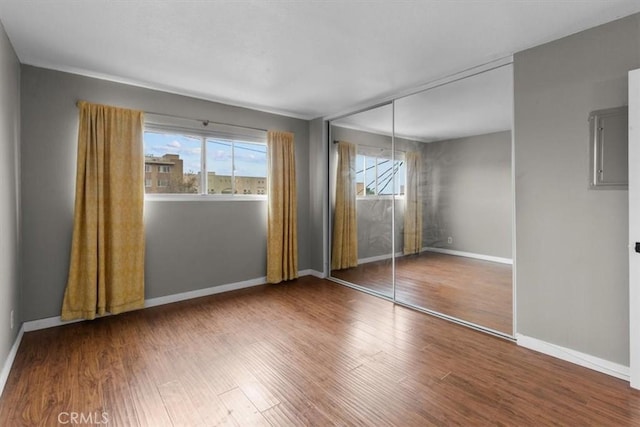 525 N Sycamore Unit 320, Los Angeles, CA 90036 - unfurnished bedroom featuring a closet, wood finished floors, baseboards, and electric panel