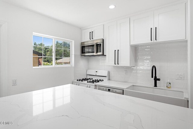 260262 Acacia St, Altadena, CA 91001 - kitchen featuring stainless steel microwave, a sink, gas range gas stove, decorative backsplash, and white cabinets