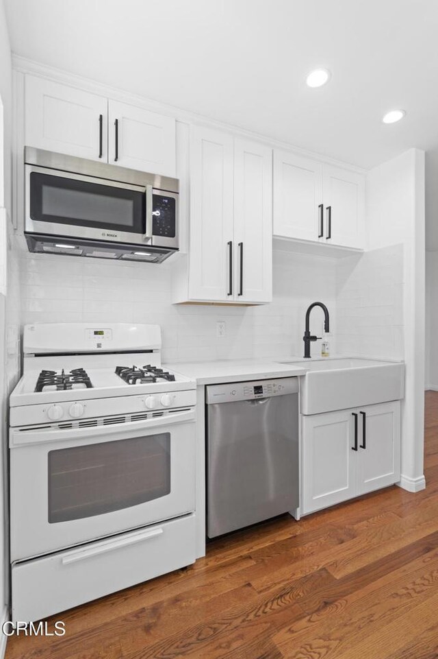 260262 Acacia St, Altadena, CA 91001 - kitchen featuring stainless steel appliances, white cabinets, light countertops, dark wood finished floors, and recessed lighting