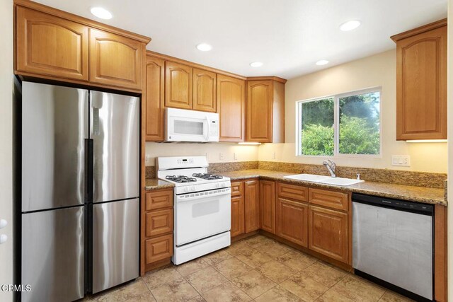 260262 Acacia St, Altadena, CA 91001 - kitchen with stainless steel appliances, a sink, recessed lighting, light stone counters, and brown cabinets