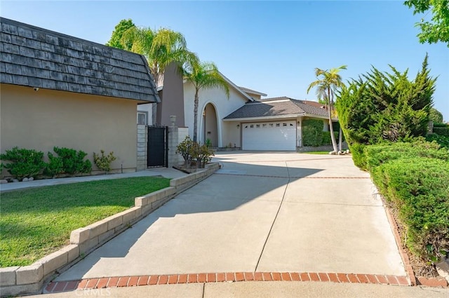 22443 Robin Oaks, Diamond Bar, CA 91765 - view of front of property featuring stucco siding, concrete driveway, a garage, a gate, and mansard roof