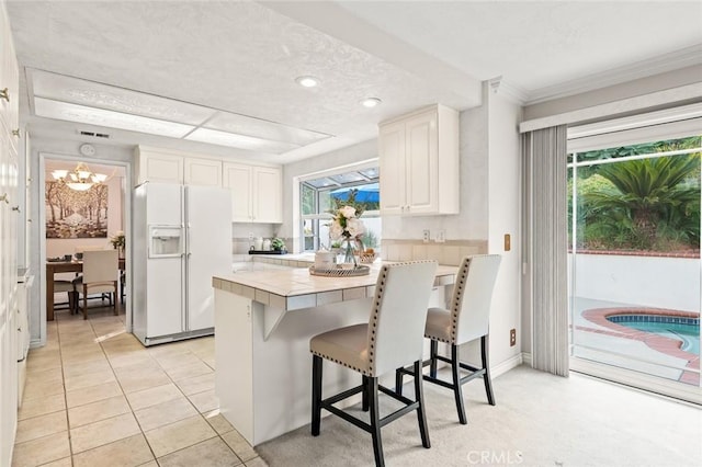 22443 Robin Oaks, Diamond Bar, CA 91765 - kitchen featuring white fridge with ice dispenser, tile counters, a kitchen bar, white cabinets, and recessed lighting