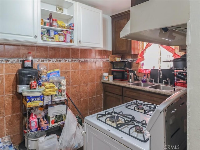 119 W 61st St, Los Angeles, CA 90003 - kitchen featuring white gas range, a sink, black microwave, white cabinetry, and tile walls