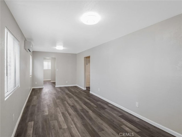 119 W 61st St, Los Angeles, CA 90003 - spare room with dark wood-style flooring, baseboards, and a wall unit AC