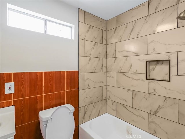 119 W 61st St, Los Angeles, CA 90003 - full bath featuring toilet, tile walls, wainscoting, and bathing tub / shower combination