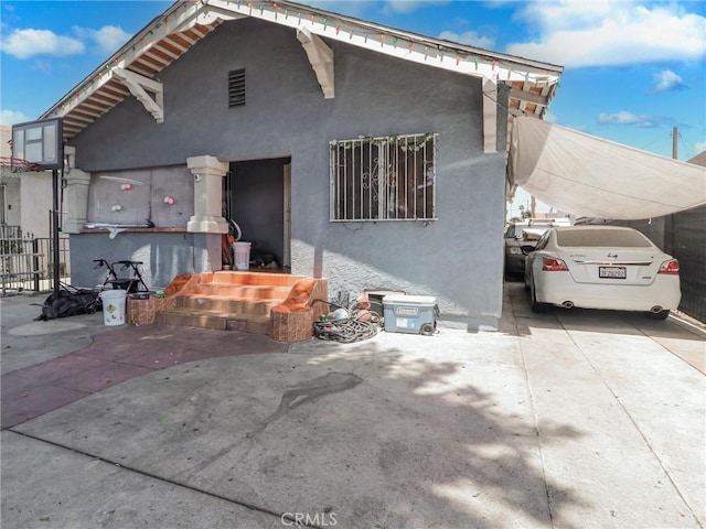 119 W 61st St, Los Angeles, CA 90003 - back of house with stucco siding and a carport