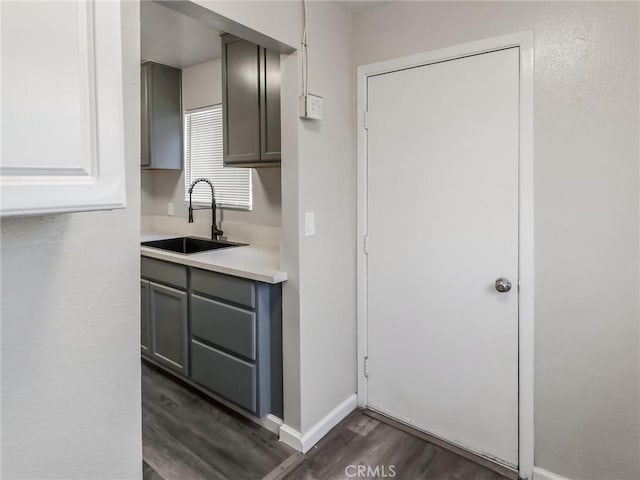 119 W 61st St, Los Angeles, CA 90003 - kitchen featuring a sink, gray cabinetry, dark wood-style floors, baseboards, and light countertops