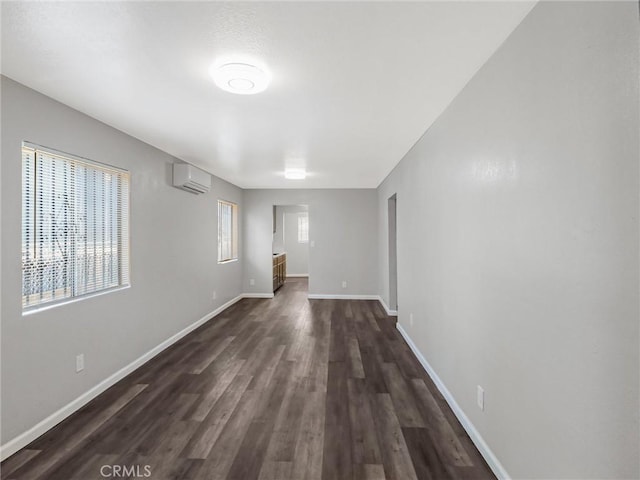 119 W 61st St, Los Angeles, CA 90003 - empty room with a wall mounted air conditioner, dark wood-type flooring, and baseboards