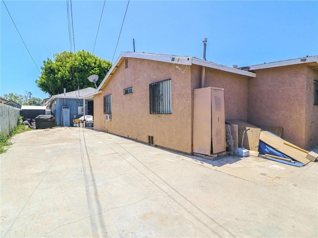 119 W 61st St, Los Angeles, CA 90003 - view of side of home with stucco siding and a patio