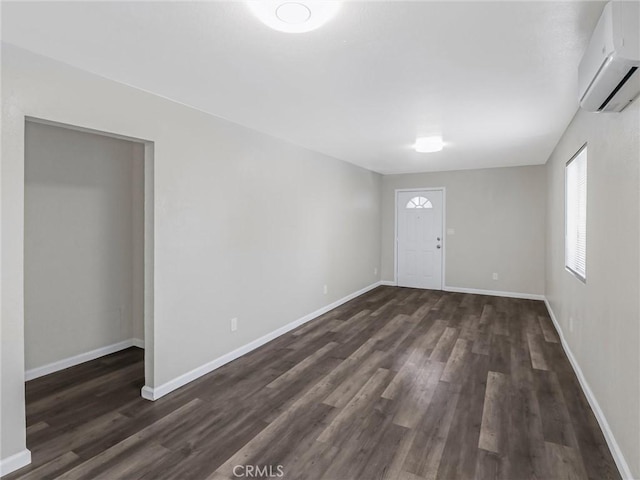 119 W 61st St, Los Angeles, CA 90003 - foyer entrance with a wall unit AC, dark wood-style flooring, and baseboards