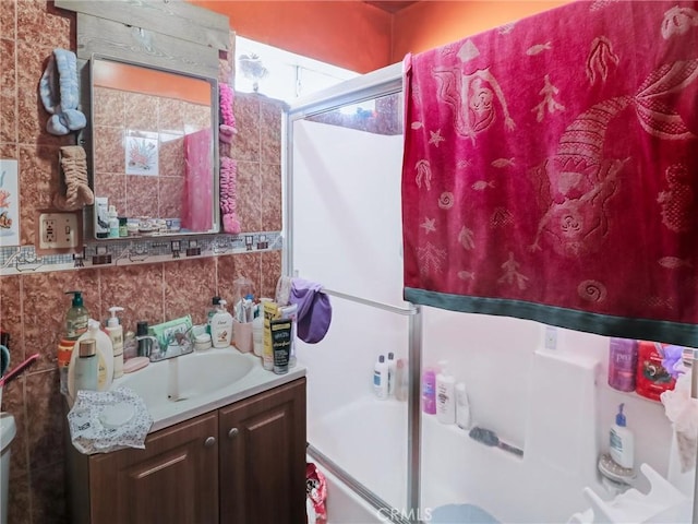 119 W 61st St, Los Angeles, CA 90003 - bathroom with vanity, shower / bath combination with glass door, and decorative backsplash