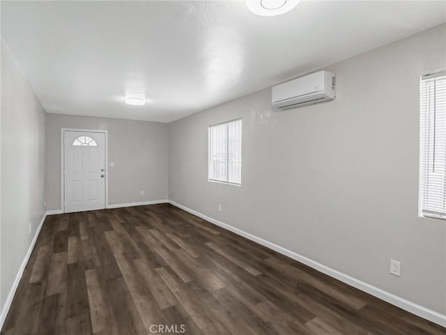 119 W 61st St, Los Angeles, CA 90003 - foyer featuring a wall mounted air conditioner, baseboards, and dark wood finished floors