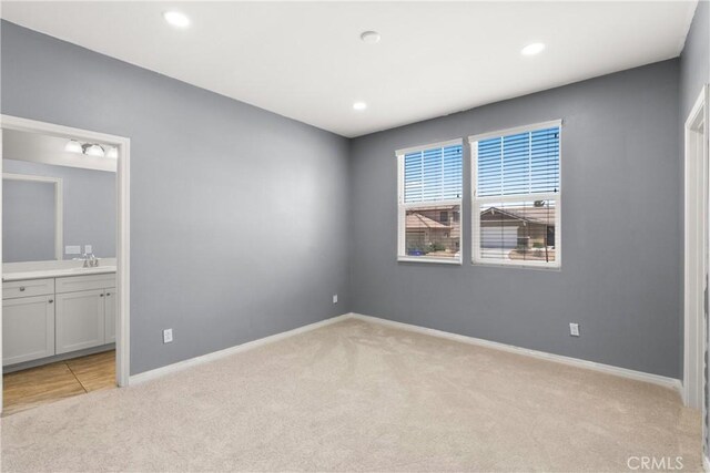 41719 Wayladn Ct, Lancaster, CA 93536 - unfurnished bedroom with light colored carpet, baseboards, ensuite bath, recessed lighting, and a sink