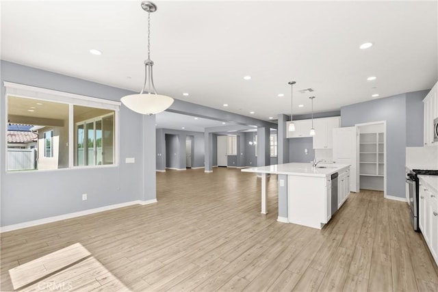 41719 Wayladn Ct, Lancaster, CA 93536 - kitchen with appliances with stainless steel finishes, open floor plan, light wood finished floors, white cabinetry, and recessed lighting