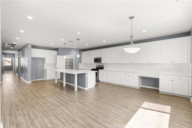 41719 Wayladn Ct, Lancaster, CA 93536 - kitchen with stainless steel appliances, white cabinetry, light countertops, light wood-type flooring, and recessed lighting