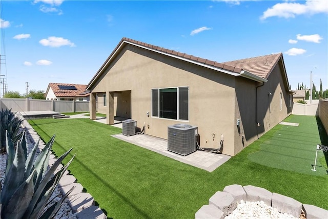 41719 Wayladn Ct, Lancaster, CA 93536 - back of property featuring an area to practice putting, stucco siding, central AC unit, a patio, and a tiled roof