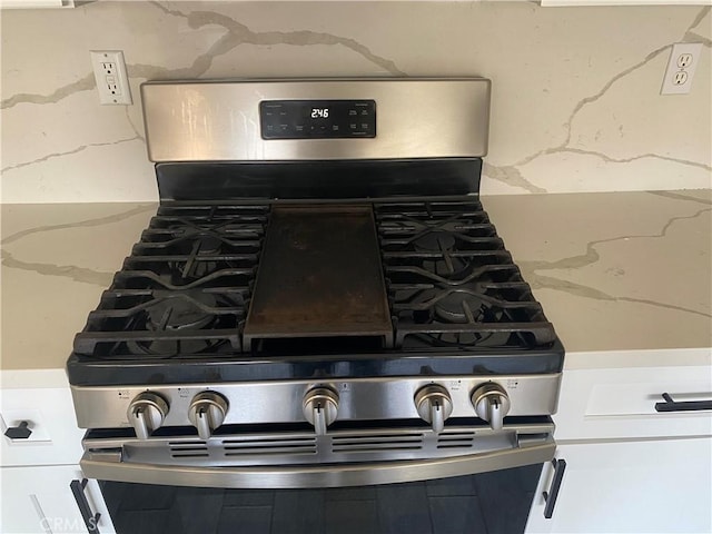 28227 Cobbler Ct, Menifee, CA 92585 - kitchen view of stainless steel gas stove, light stone counters, and tasteful backsplash