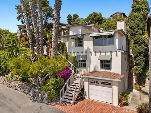 790 Wendt Ter, Laguna Beach, CA 92651 - view of front of property featuring decorative driveway, stucco siding, stairway, and a chimney
